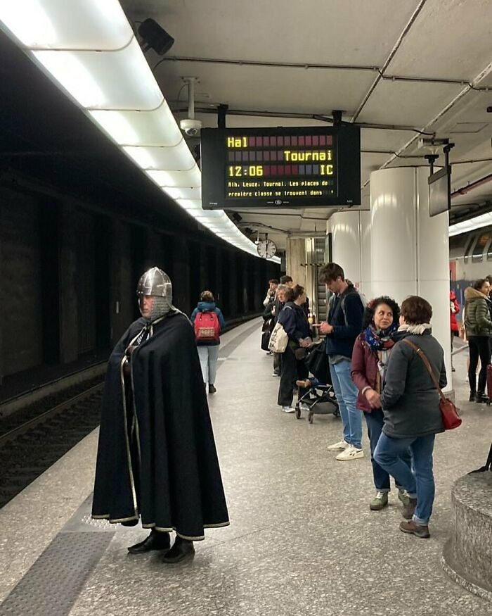 Rycerz sprawdza, czy metro w Brukseli honoruje średniowieczne zbroje.