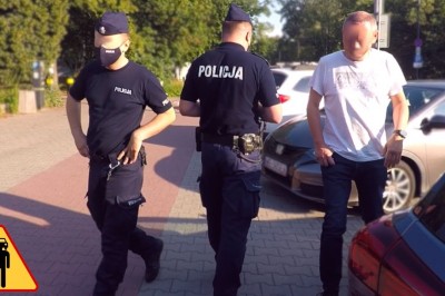 Policjant popycha pieszego na chodniku. Nagranie z Warszawy