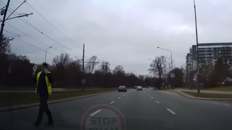 Policjant wbiega na 3 pasmową ulicę, aby zatrzymać auto