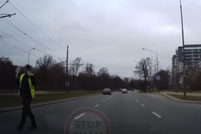 Policjant wbiega na 3 pasmową ulicę, aby zatrzymać auto