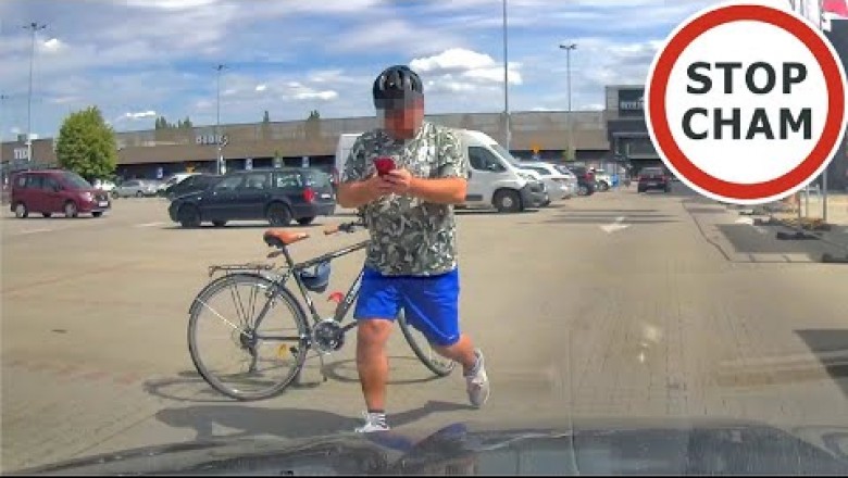 Agresywny rowerzysta biega po parkingu za samochodem. Nagranie z kamery