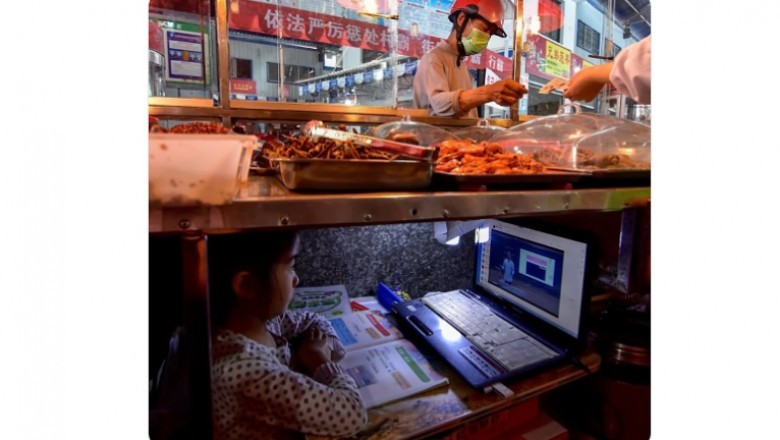 Mała dziewczynka z Chin uczy się online pod straganem swoich rodziców